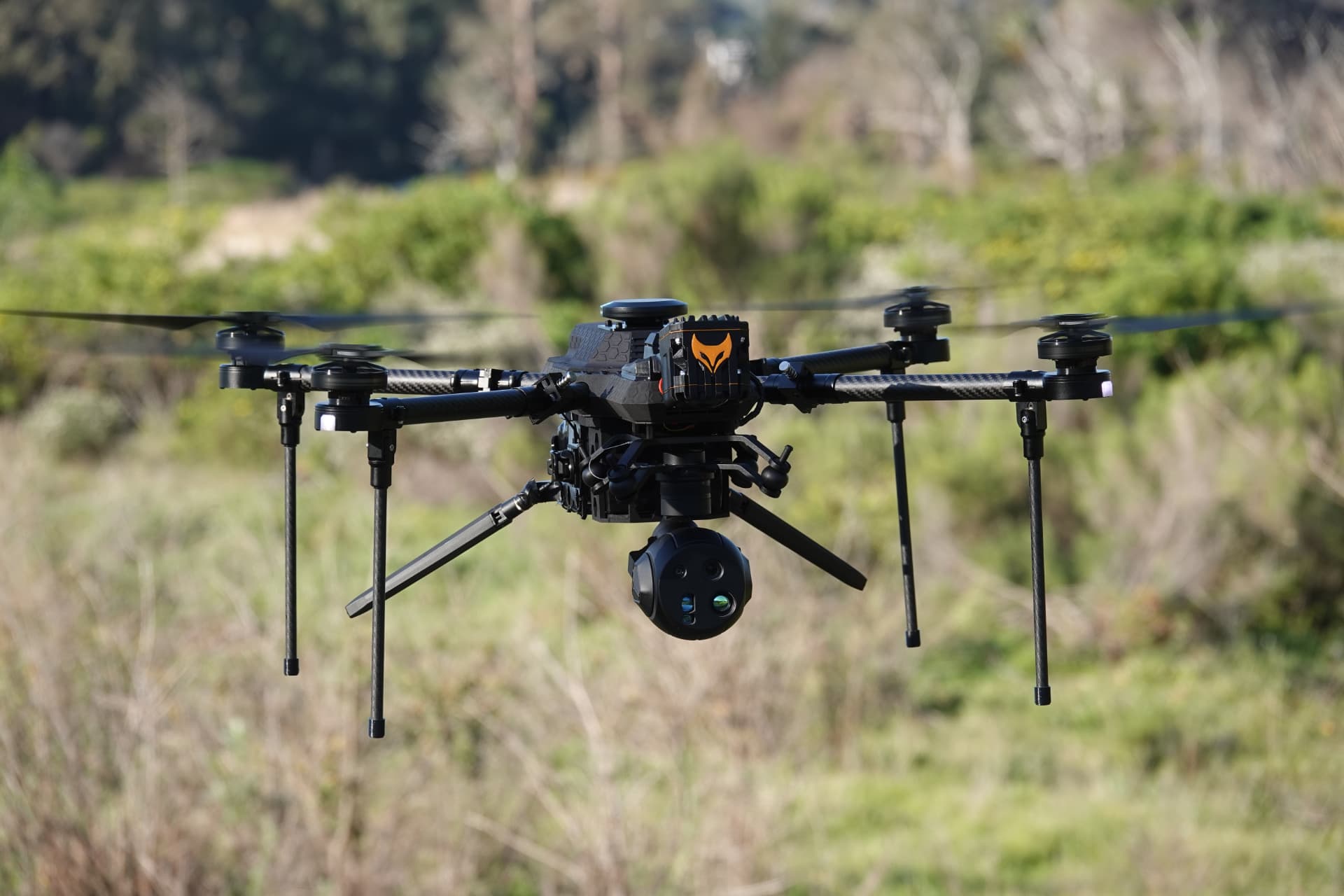 TCAT RECCE surveillance drone hovering over open terrain during a reconnaissance mission TCAT RECCE surveillance drone hovering over open terrain during a reconnaissance mission