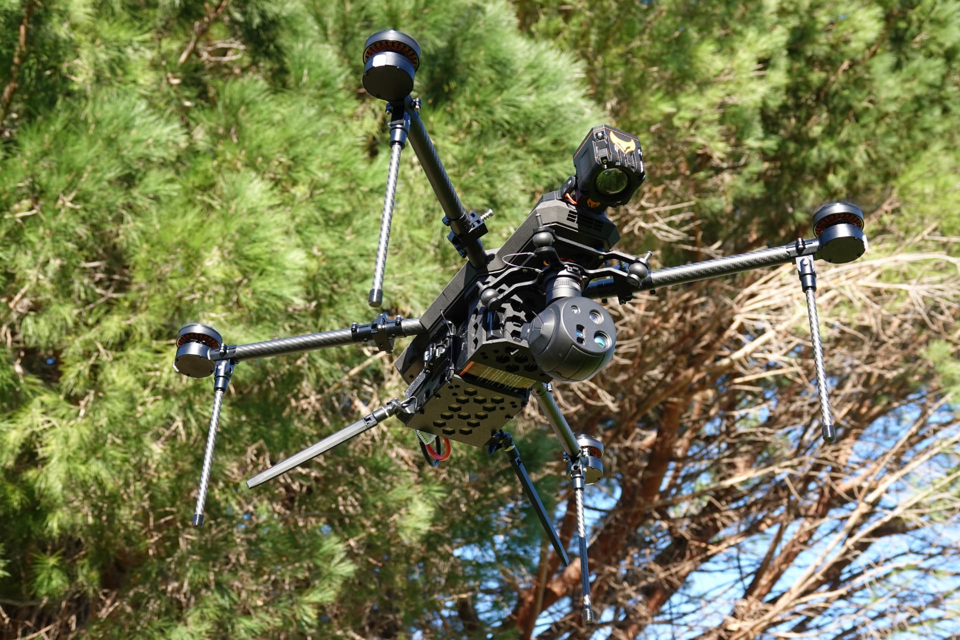 TCAT RECCE reconnaissance drone banking above a treeline TCAT RECCE reconnaissance drone banking above a treeline